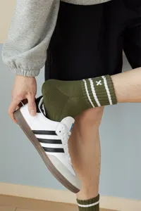Detail view of men's athletic mid-tube socks featuring breathable looped bottom and embroidery.