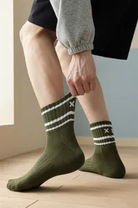 Detail shot of army green athletic crew socks with white stripes and embroidered X logo.