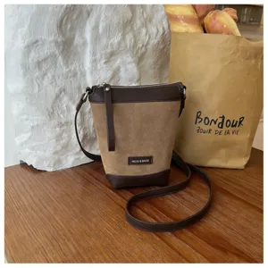 Close up detail of brown suede crossbody phone bag showing texture and slim shoulder strap.