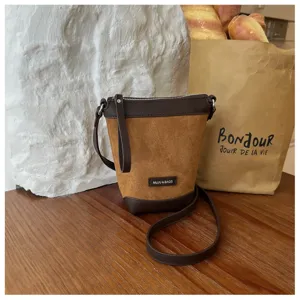 Detailed view of the brown suede mini crossbody phone bag with dark leather trim and strap.