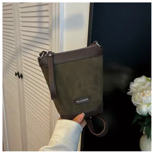 Detail shot of the contrast color suede and leather mini crossbody phone bag with zipper.