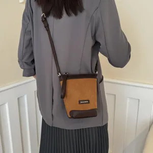 Detail shot of the brown bucket crossbody bag worn by model, showing adjustable strap.