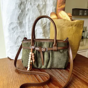 Dettaglio borsa a spalla in camoscio verde rétro, borsa casual con ciondolo di perline.