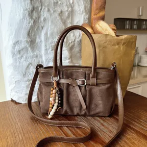 Dettaglio borsa a tracolla marrone stile retro, grande capacita, comoda borsa casual da donna.