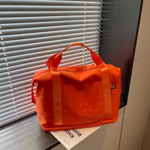 Orange travel duffel bag for women, large portable fitness sports gym bag with handles.