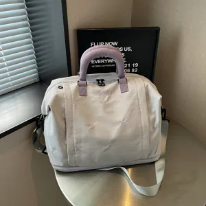 Bolso de viaje grande y espacioso con bonitos lazos bordados y asas moradas detalle.