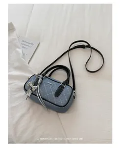 Denim gesteppte Kissentasche Detail, stilvolle schwarze Henkel und süßer Metallanhänger.