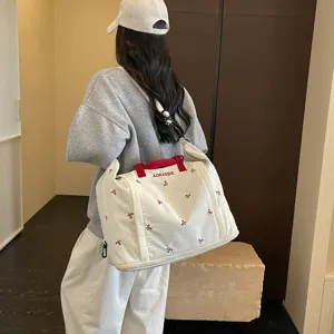Bolsa de viaje grande con asas rojas y bonito bordado de lazos para viajes cortos.