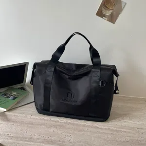 Black travel duffel bag for women, portable tote and casual sports fitness gym bag detail.