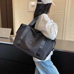 Stylish black travel duffel bag for women, portable shoulder bag for gym, sports, and weekend trips.