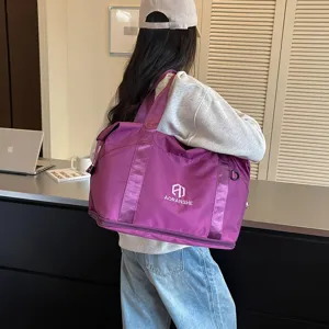 Women's purple travel duffel bag detail, portable shoulder strap and bottom zipper compartment.