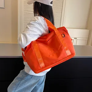 Detailed close-up view of the orange travel gym bag showcasing shoulder strap and design.