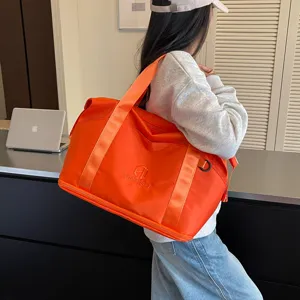 Orange travel duffel bag for women, portable shoulder fitness bag with large capacity.