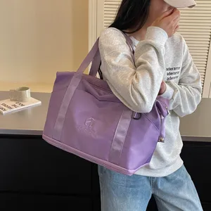 Stylish purple travel duffel bag for women, spacious gym and sports shoulder bag with handles.