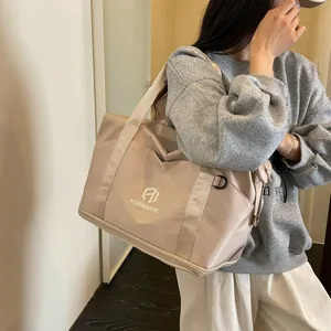 Beige travel duffel bag for women, large capacity gym sports shoulder bag for casual use.