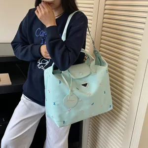 Ruime mintgroene tote tas met leuke borduursel en stijlvol design voor reizen of werk.