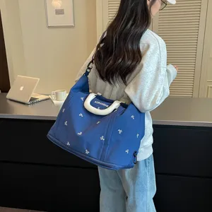 Detalle de bolsa de viaje espaciosa de tela azul resistente con elegantes patrones de lazos.