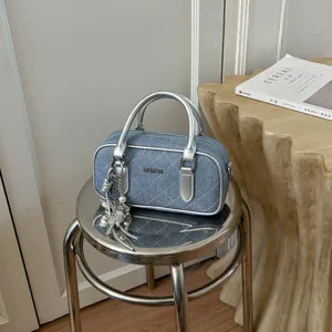 Detailansicht der modischen Jeans-Stepptasche mit schicken silbernen Metallgriffen.