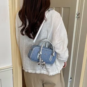 Detailansicht der schicken blauen Stepp-Schultertasche mit schönen metallischen Griffen.