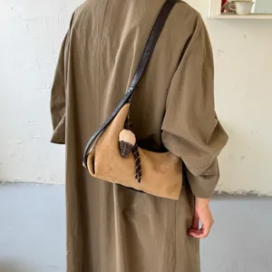 Detailweergave van Koreaanse retro suède schoudertas met stijlvolle riem en hanger.
