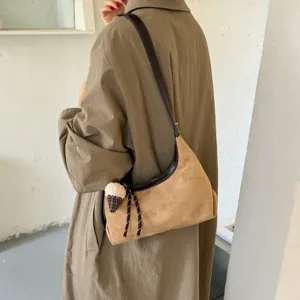 Gedetailleerde close-up van bruine suède hobo schoudertas in casual Koreaanse stijl.