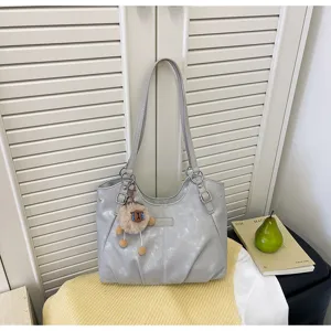 Vista dettagliata della borsa a spalla in pelle PU grigio argento con ciondolo di pecora.