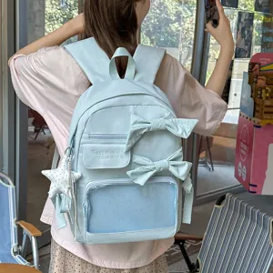 Detailansicht des hellblauen süßen Schulrucksacks mit süßen Schleifen und Anhängern.