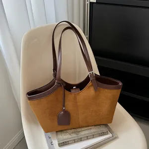 Retro brown suede tote bag detail, featuring dark brown leather trim and handle, stylish look.