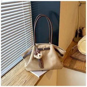 Detail shot of canvas pleated tote bag, brown handles, cute bear pendant, daily style.