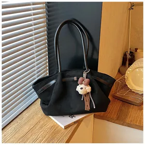 Detail shot of the fashionable black pleated tote handbag with dual handles and a puppy charm.