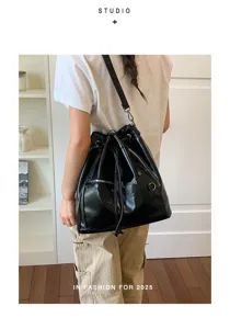 Schwarze PU Leder Beuteltasche mit Kordelzug, Metall Reißverschlusstaschen und schickem Design.