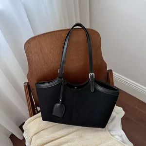 Detail shot of black suede shoulder tote bag, elegant minimalist design for daily wear.