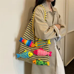 Primo piano delle decorazioni colorate di pesci di peluche sulla borsa in maglia.