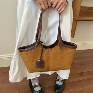 Detailed close-up view of vintage brown suede tote bag featuring dark leather handles and trim.