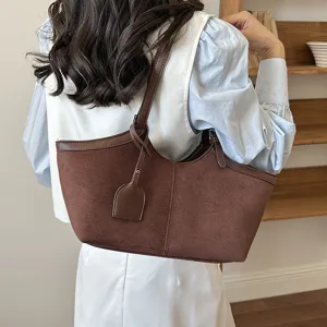 Detail view of brown suede shoulder tote bag, soft texture and stylish knot strap design.