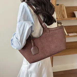 Detail view of a retro brown suede shoulder bag, showcasing premium texture and elegant strap.
