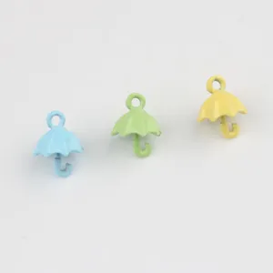 Close-up of colorful alloy umbrella charms in blue, green, and yellow for DIY jewelry making.