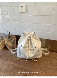 Detailansicht des weißen PU-Leder Kordelzug Rucksacks mit Metallreißverschluss Ösen.