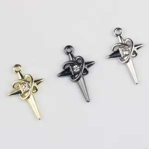 Dettaglio del ciondolo croce stella in zircone e lega, nei colori oro, nero e argento.