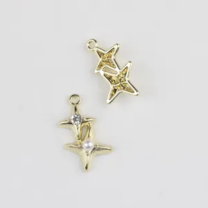 Détail en gros plan du pendentif charme étoile double, alliage plaqué or avec perle et zircone.