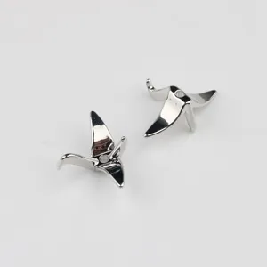 Close up detail shot of silver origami crane metal spacer beads for DIY jewelry design