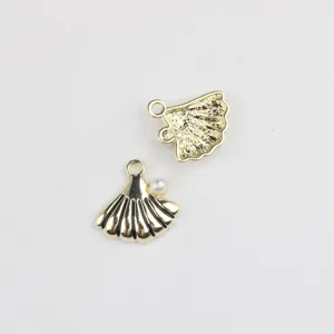Vue détaillée d'un pendentif coquillage doré avec perle, idéal pour la création de bijoux.