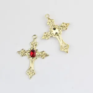 Ciondolo croce vintage dorata con pietra rossa, incisione metallica dettagliata per gioielli.