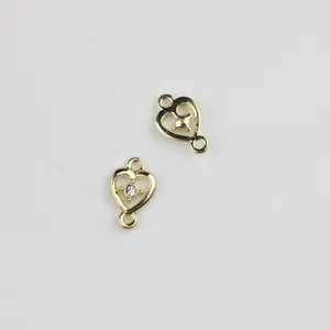 Detailed view of gold alloy heart double hanging jewelry connector with clear zircon inlay.