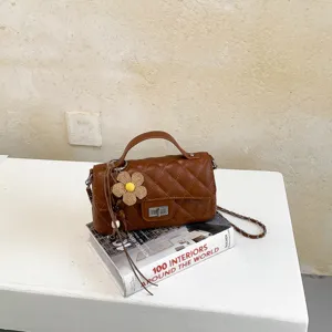 Καφέ καπιτονέ τσάντα χιαστί λεπτομέρεια με κομψό στιλ, πολυτελή όψη και συμπαγή σχεδιασμό.