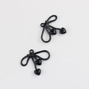 Close-up view of black alloy bow heart charms, perfect for DIY jewelry making details.