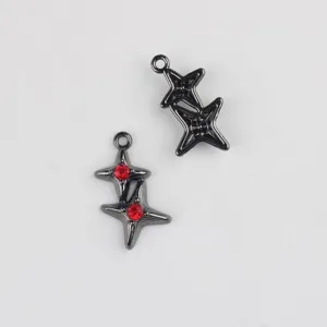 Gros plan de pendentifs double etoile en metal gunmetal avec strass rouges pour bijoux DIY.