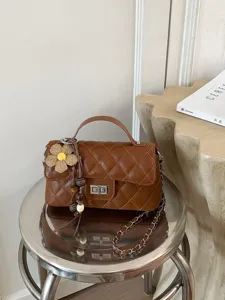 Braune gesteppte Kettentasche mit Henkel und Blumenanhänger für Damen, elegante Alltagstasche.
