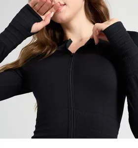 Dettaglio giacca sportiva yoga a maniche lunghe a coste nera con zip e fori pollice.
