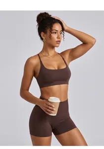 Detailansicht eines braunen Sport-BH- und Yogashorts-Sets, getragen von Model im Studio.